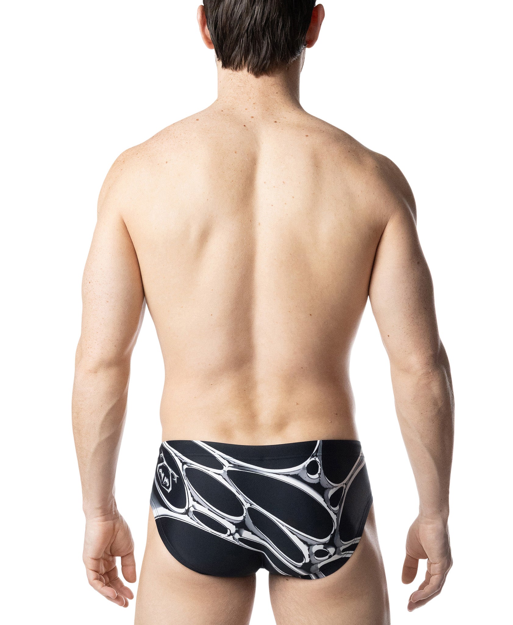 Man wearing black swim briefs with white abstract design on a white background
