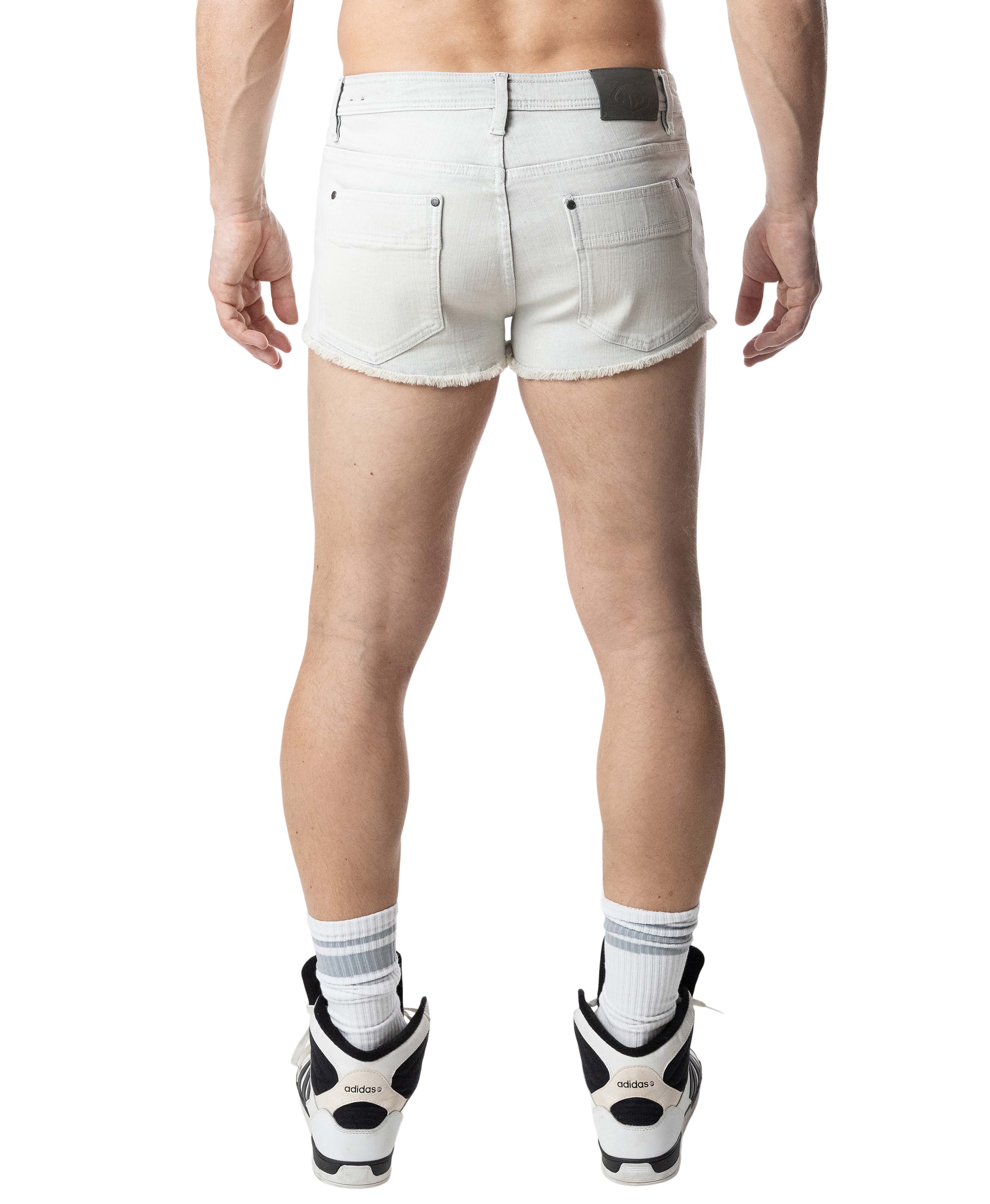 Person wearing white denim shorts on a white background