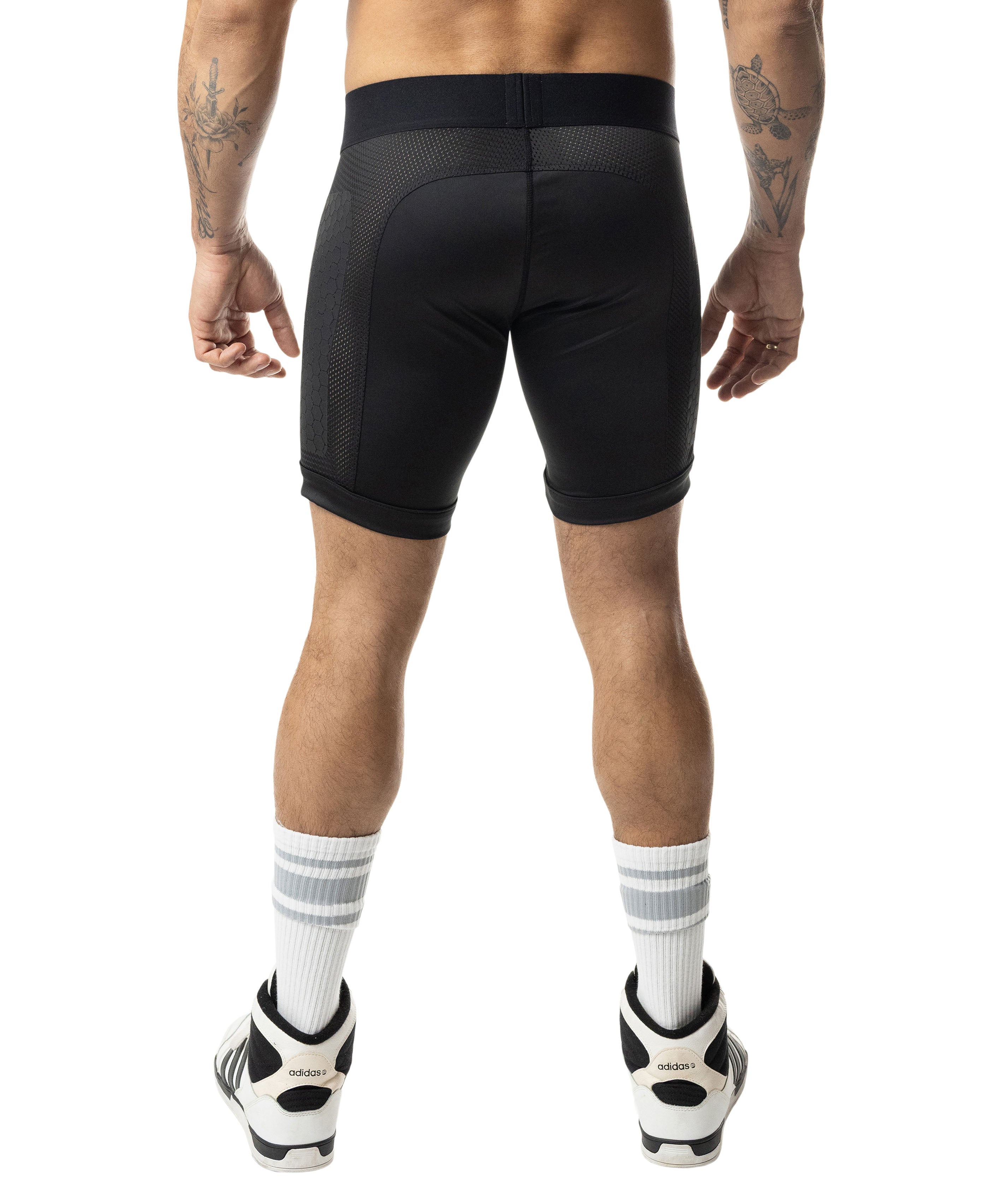Person wearing black athletic shorts on a white background