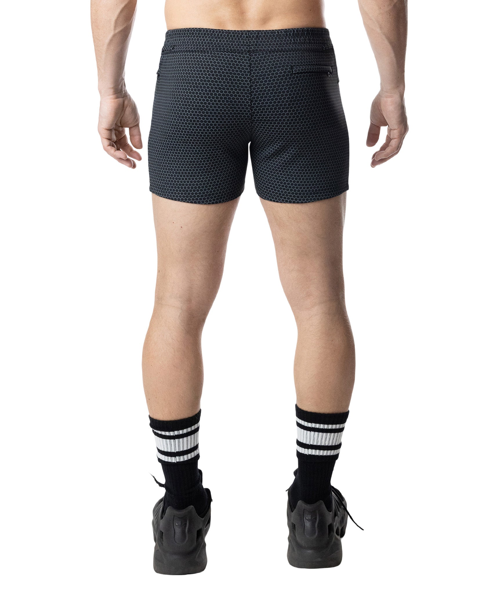 Person wearing black patterned shorts on a white background