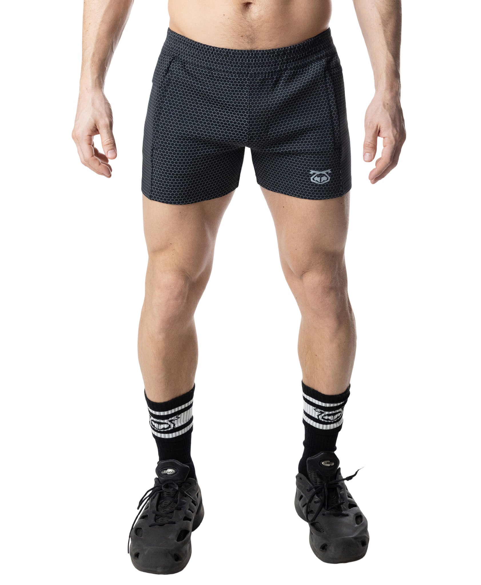 Person wearing black patterned shorts on a white background