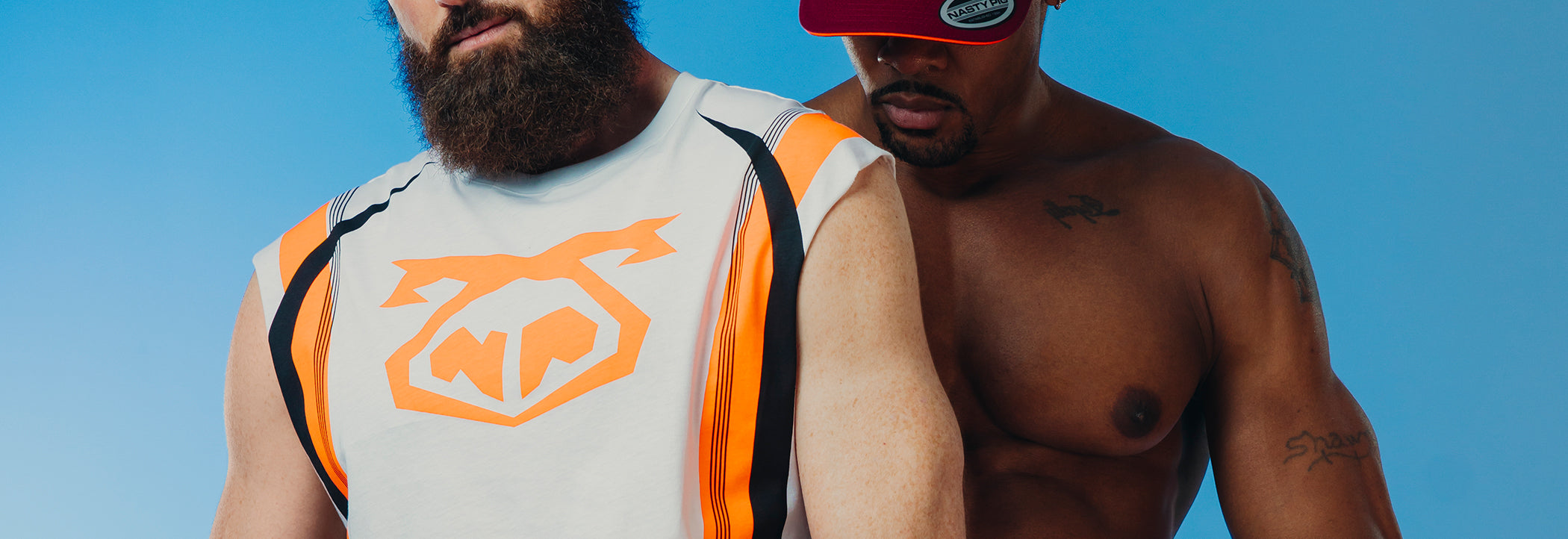Two men embracing while wearing tank tops