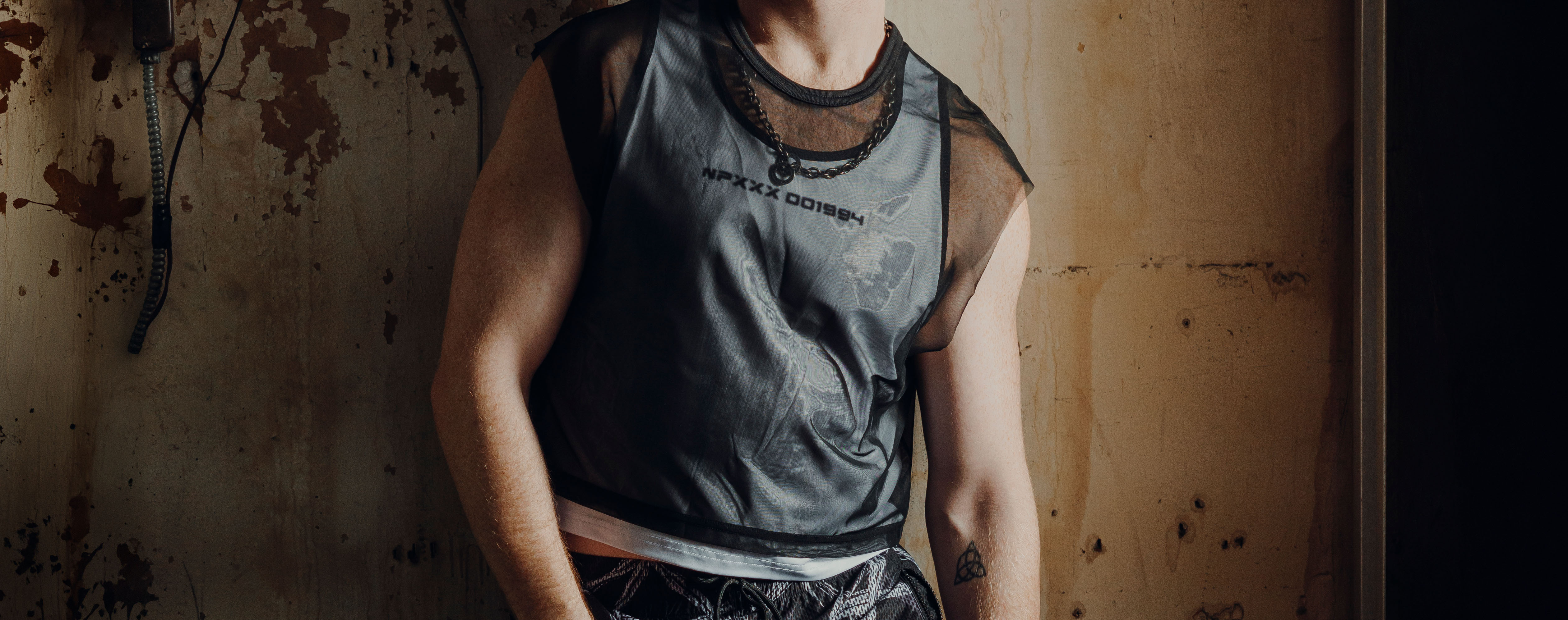 Two men embracing while wearing tank tops