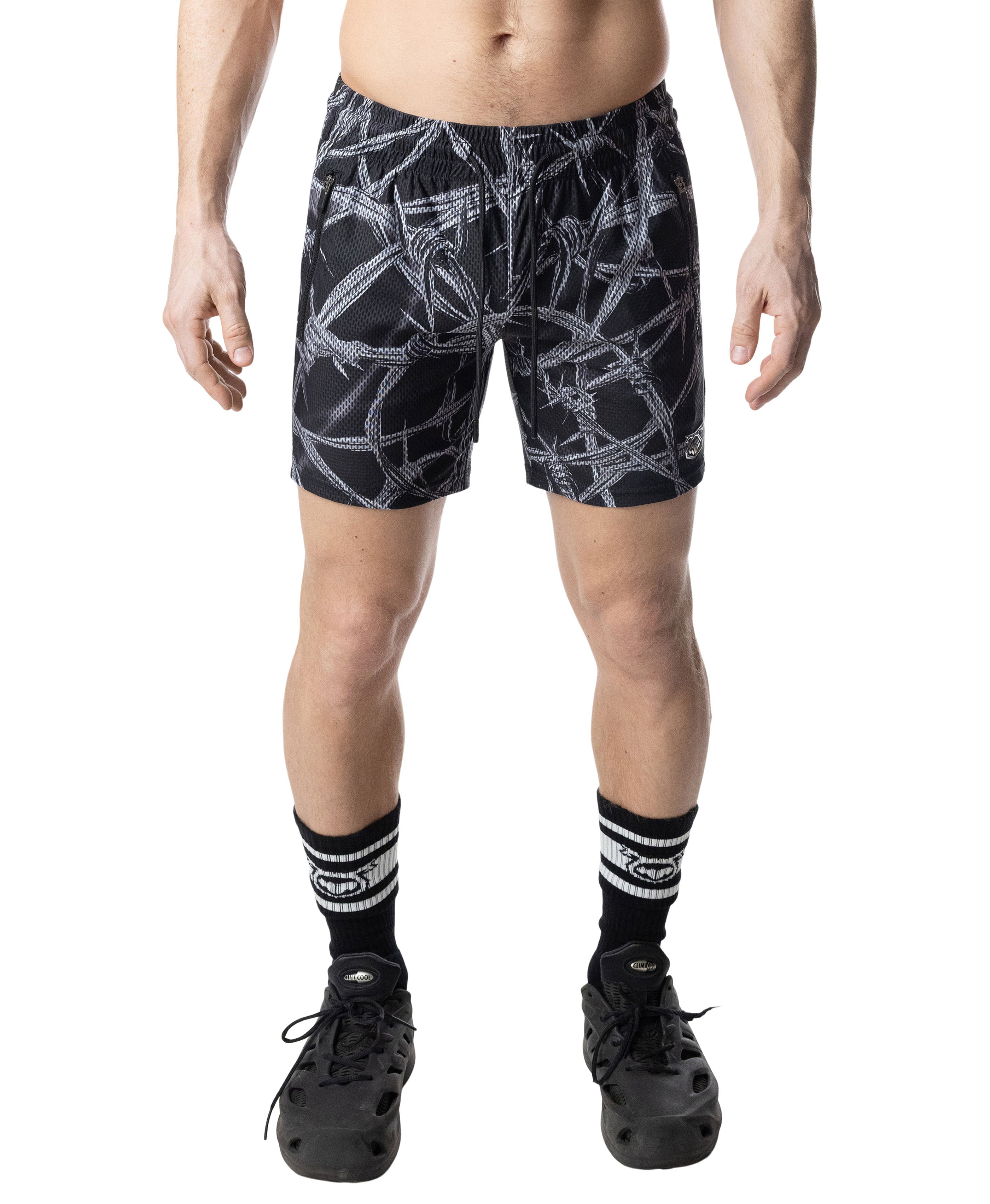 Person wearing black shorts with white abstract pattern on a white background