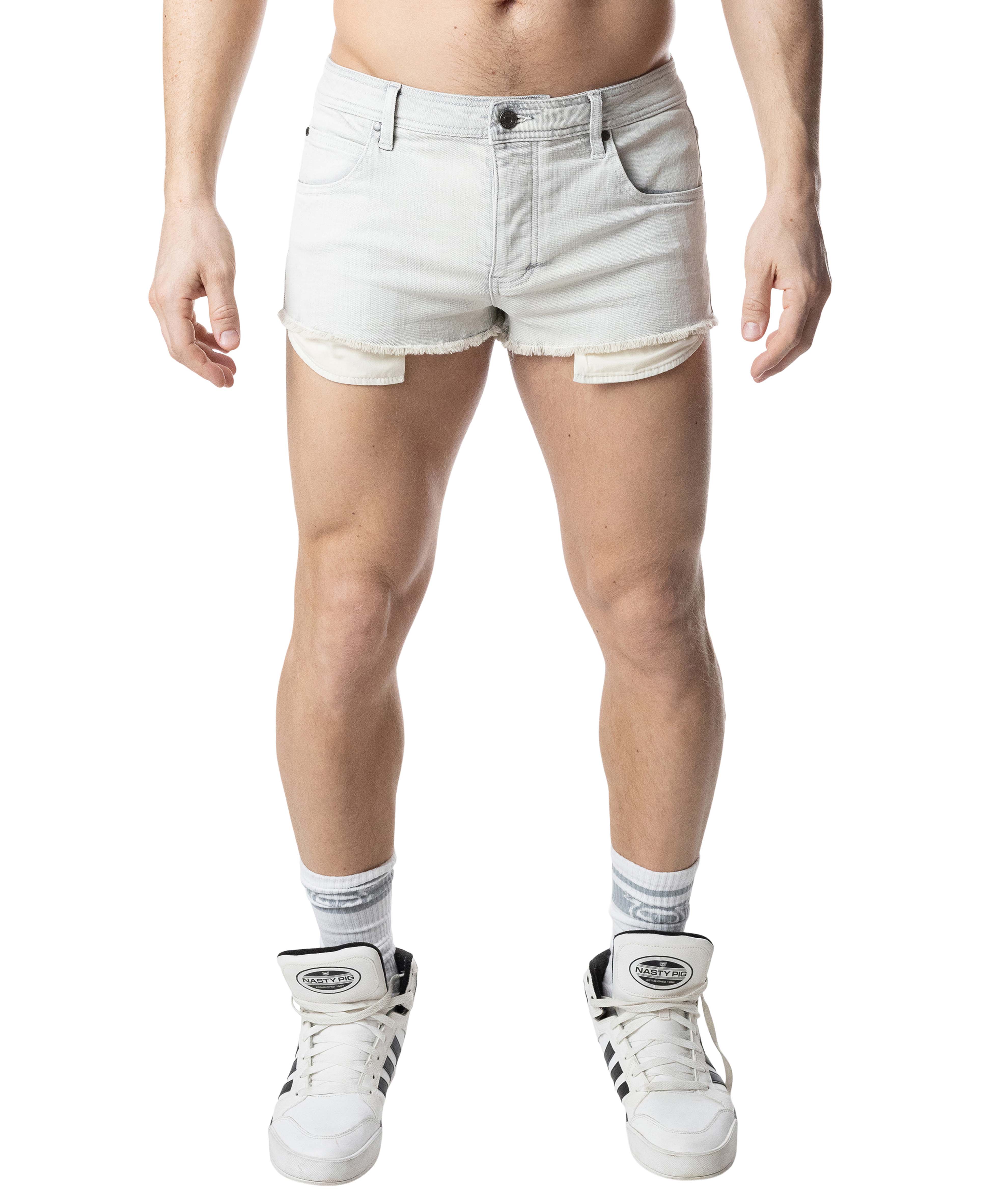 Person wearing light-colored denim shorts and white sneakers on a white background