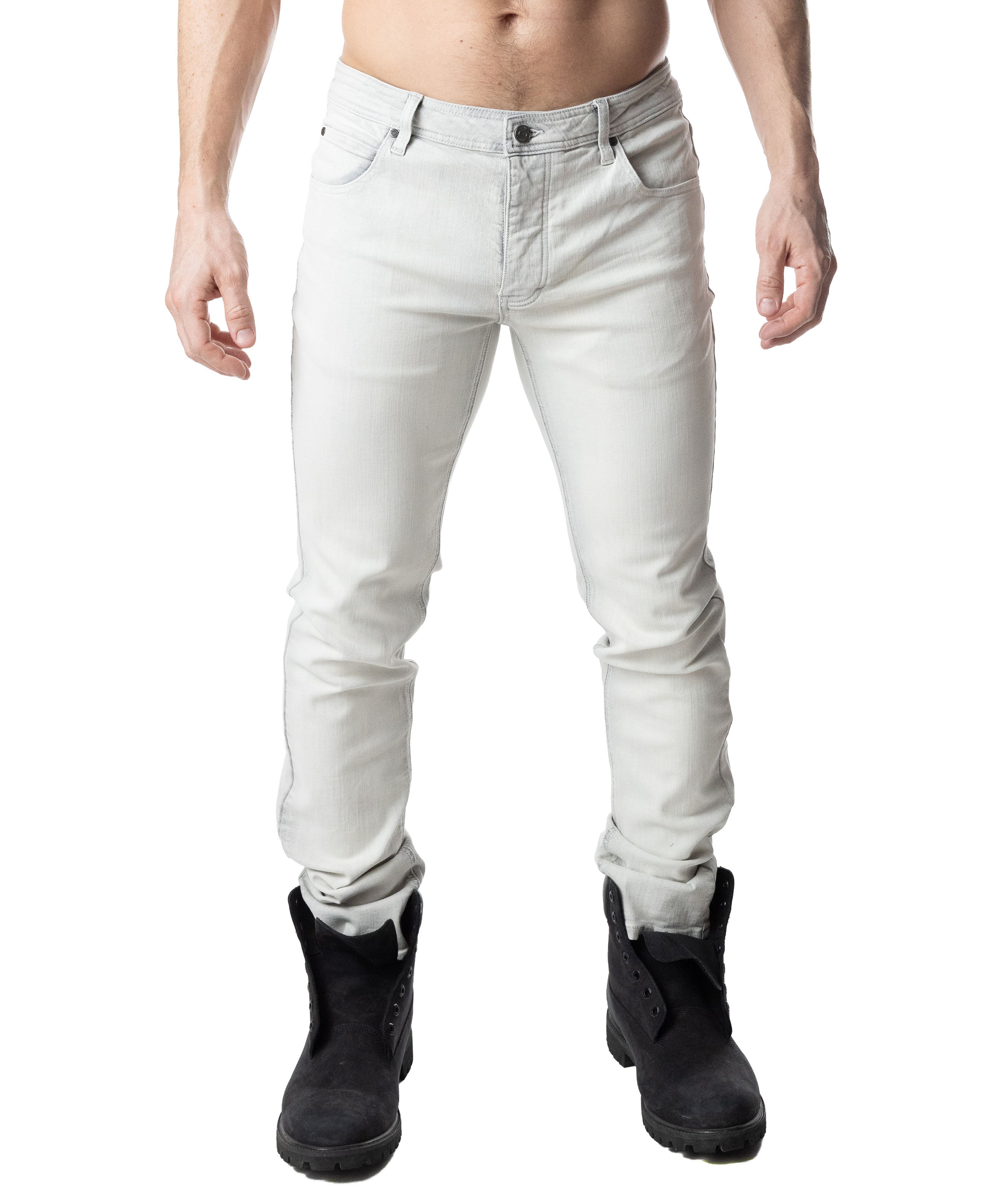 Person wearing light gray jeans and black boots on a white background