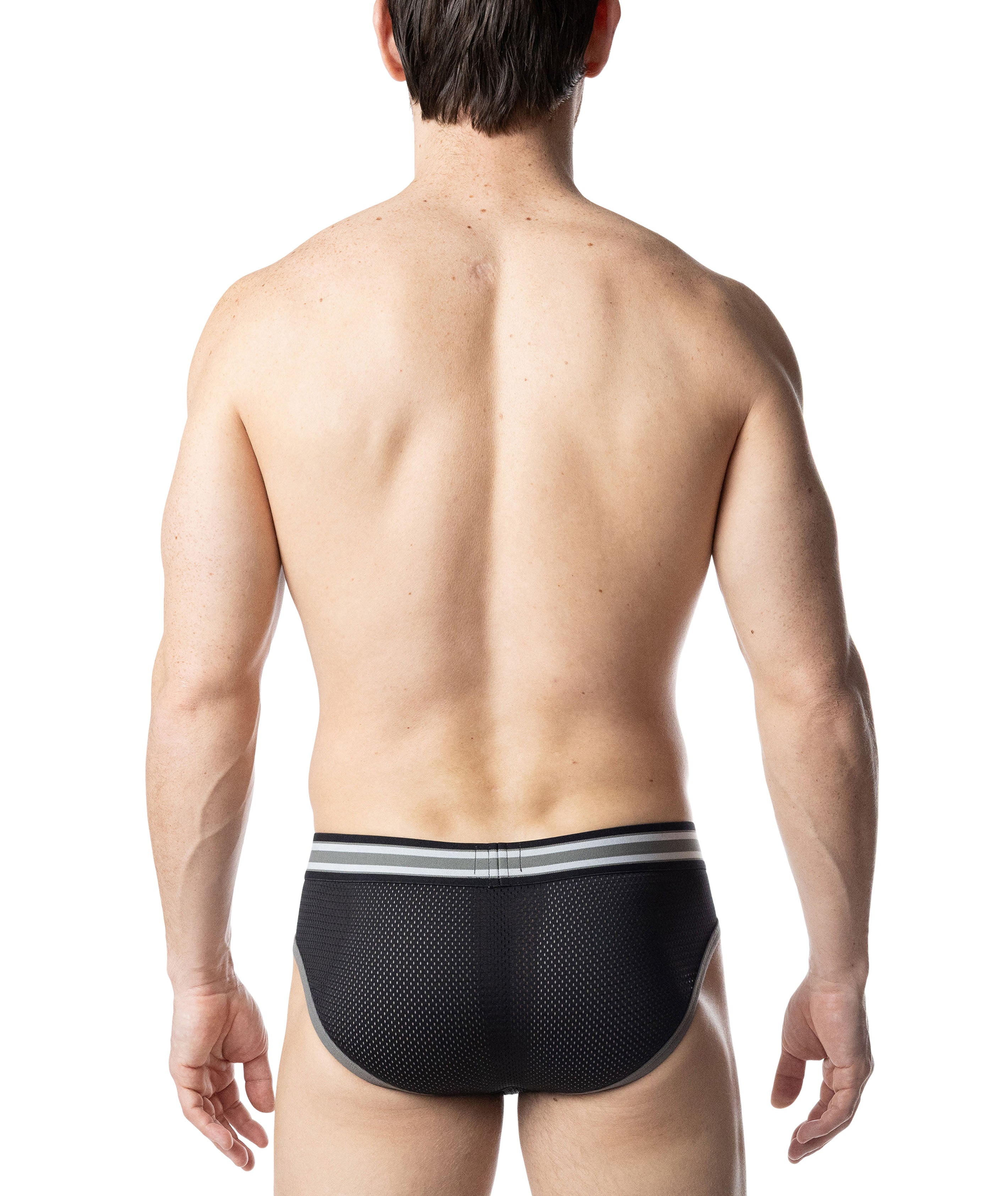 Man wearing a black mesh underwear with white stripes on a white background