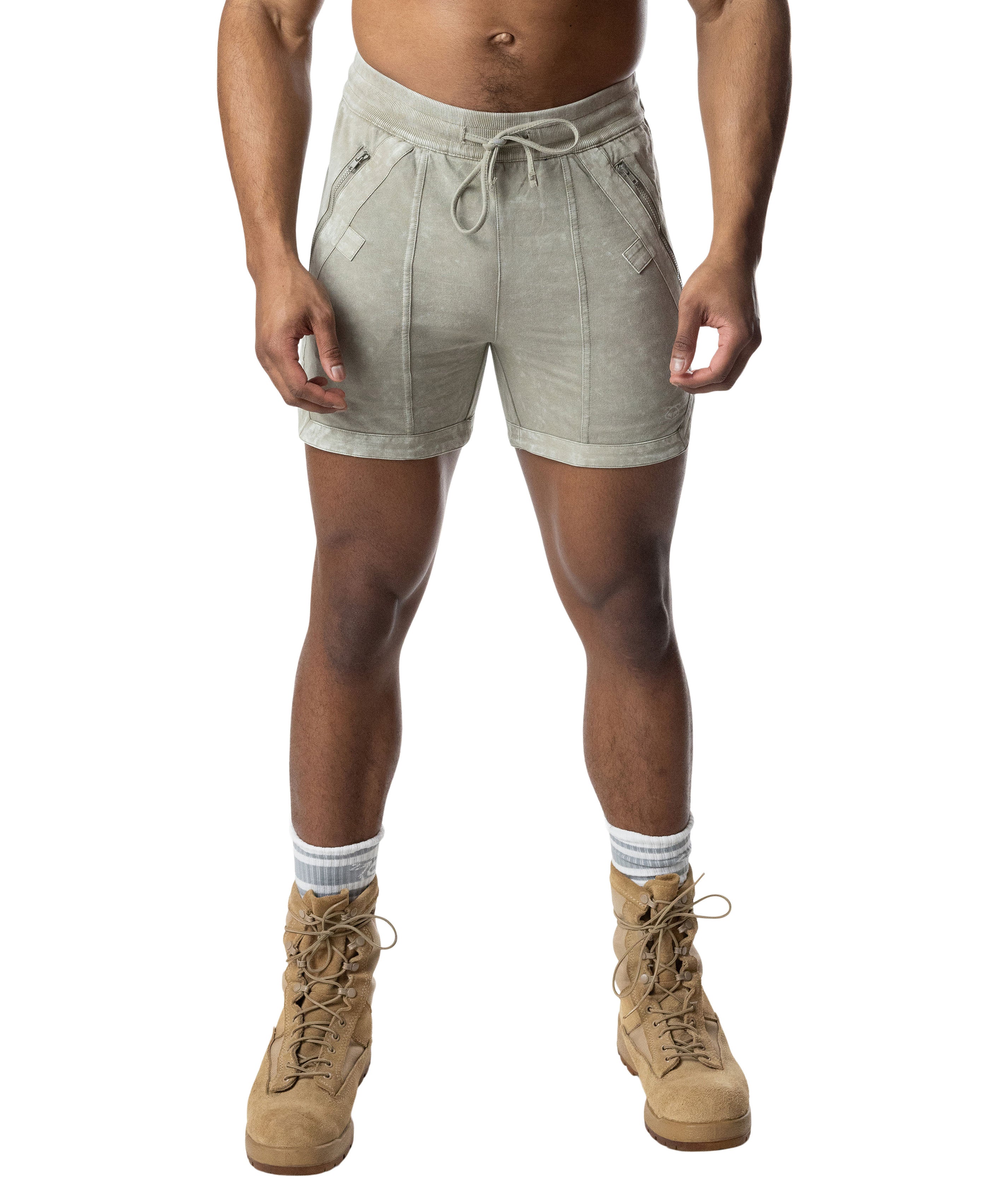 Person wearing green shorts and tan boots on a white background